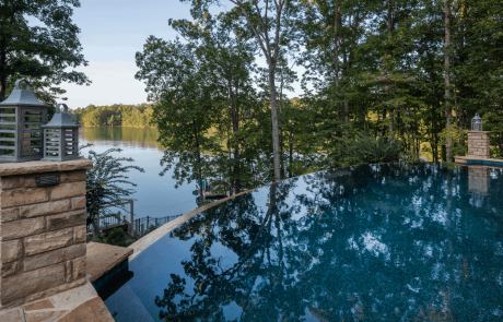 Perched high above Lake Lanier, this stunning infinity edge pool was custom designed to take advantage of the breathtaking views and its natural surroundings. Irregular Tennessee flagstone pool coping and stacked stone pedestals highlight the pool’s reflective beauty and gorgeous dark blue water.