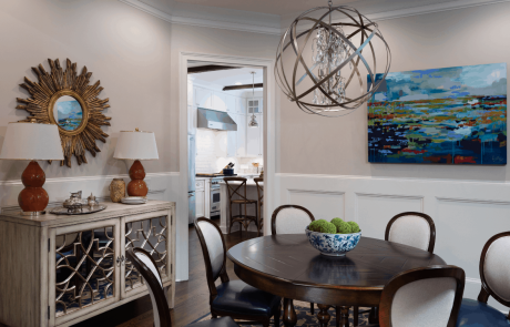 Transitional style dining room with gray walls, round dining table, blue & white dining chairs, gourd table lamps and wood frame mirror in Antique Bronze.