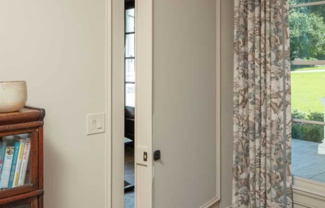 Master bedroom with secret hidden door, custom wall paneling and trim work in Benjamin Moore’s Edgecomb Gray.