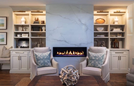 Keeping room renovation includes a dramatic white porcelain slab surround with linear fire feature and custom built-in cabinetry and trim work, and brown hardwood floors.