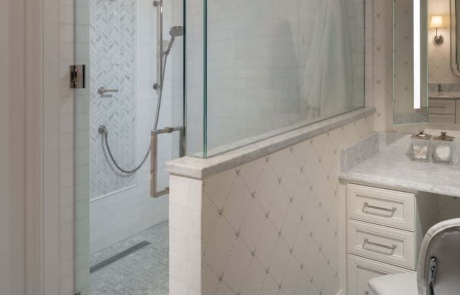 Second story bathroom addition includes a frameless walk-in shower with hinged door, white marble tile walls with gray mosaic accent tile wall, polished nickel fixtures, separate make up vanity with quartz countertops and Carrera Bianco marble floor.