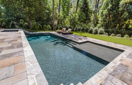 Modern Pool with Tanning Ledge, Flush Spa, Irregular Flagstone Coping, Belgard Origins Paver Patio, & Outdoor Pool Entertainment Areas.