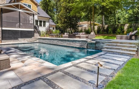 Contemporary Backyard Retreat boasts Swimming Pool with Raised Flush Spa & Spillover, Premium Pool Finishes, Stacked Stone Raised Beam, Stone Paver Patio & Modern Stepping Stones.