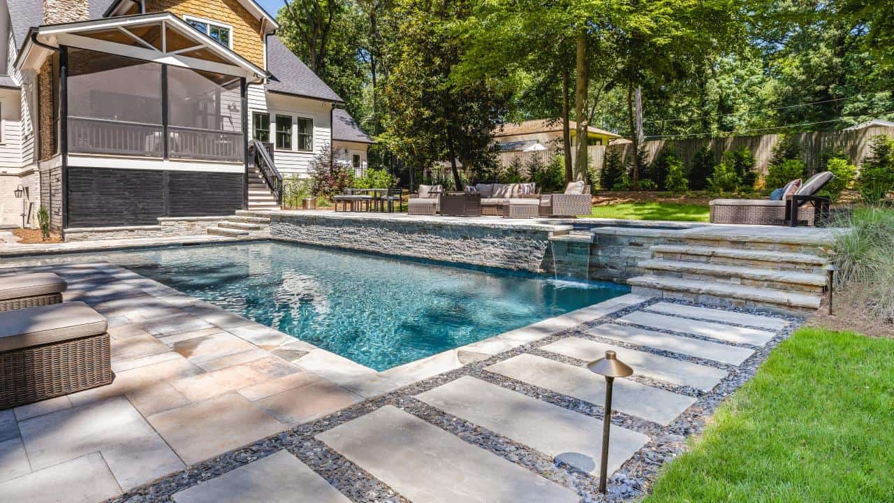 Contemporary Backyard Retreat boasts Swimming Pool with Raised Flush Spa & Spillover, Premium Pool Finishes, Stacked Stone Raised Beam, Stone Paver Patio & Modern Stepping Stones.