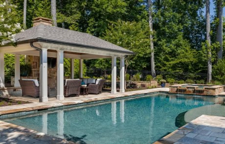 Beautifully landscaped backyard features a modern pool & spa with large tanning ledge, elegant gazebo with outdoor fireplace, spacious paver patio and serene wooded surroundings, perfect for unwinding or entertaining guests.