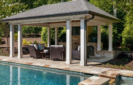 Pool house addition features a large covered outdoor entertainment area, paver patio and custom outdoor fireplace with stunning views of the adjoining resort-style pool and spa.