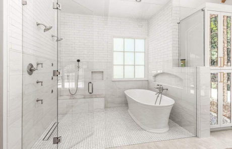 Spa-inspired bathroom features custom wet room with walk-in shower, dual shower heads, built-in shower niche, white freestanding tub, polished nickel bathroom fixtures and mosaic tile flooring.