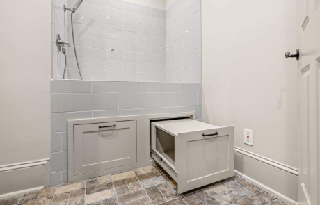 Dedicated dog washing station, custom-built with tile surround, raised platform, pull-out drawers and a handheld shower.