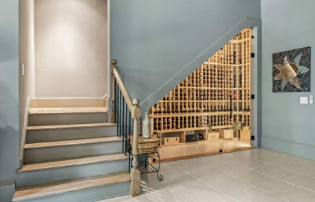 Innovative wine cellar design features a modern under-staircase wine cellar with wooden wine racks and LED lighting.